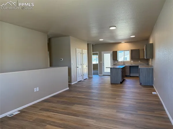 a kitchen with kitchen island granite countertop wooden floors and white stainless steel appliances