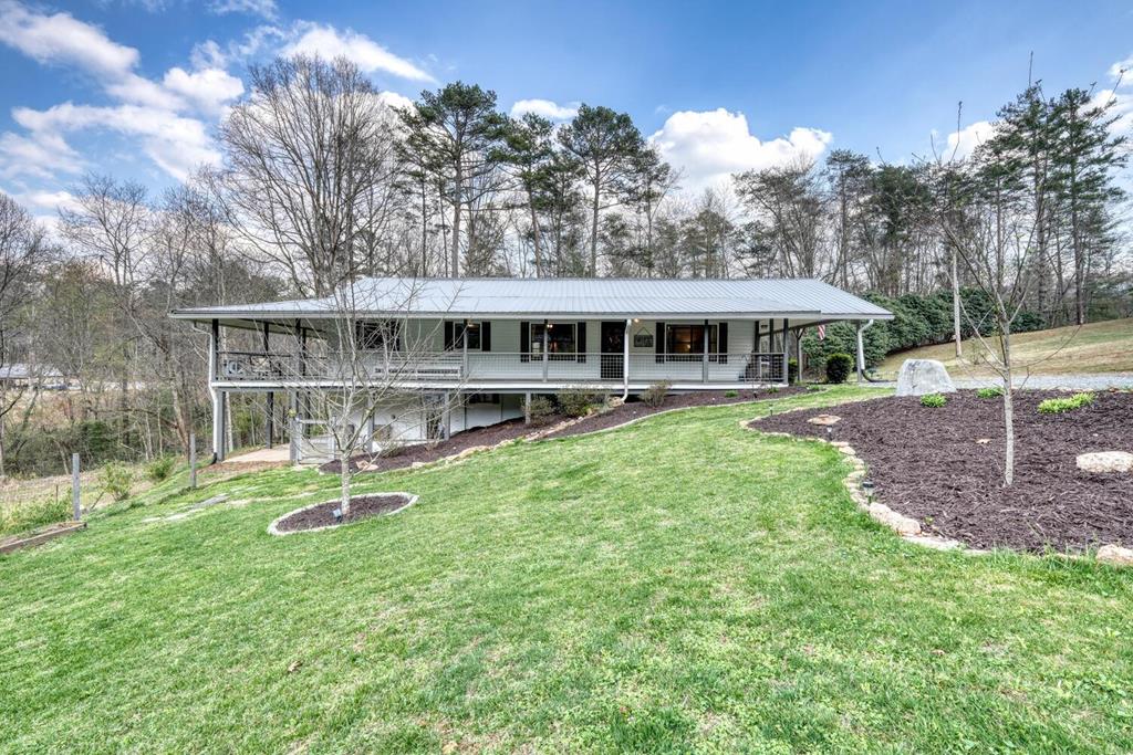 a view of a house with a yard and sitting area