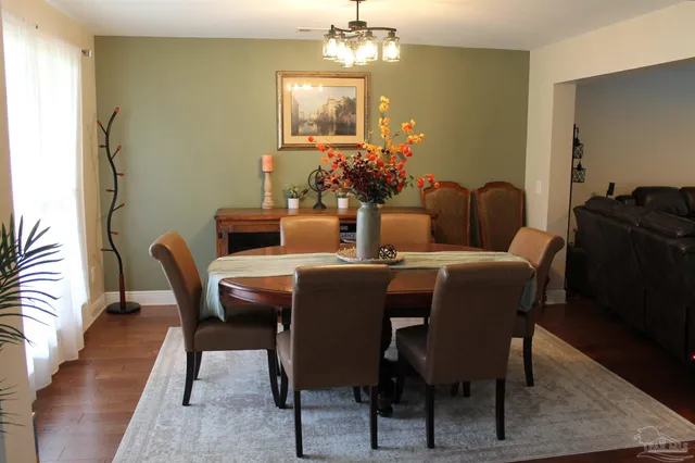 a dining room with furniture a chandelier and wooden floor
