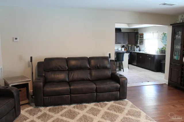 a living room with a couch and a view of kitchen counter top space