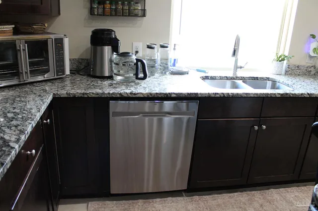 a kitchen with granite countertop a sink and cabinets