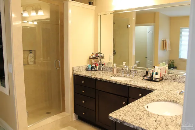 a bathroom with a granite countertop sink and a mirror