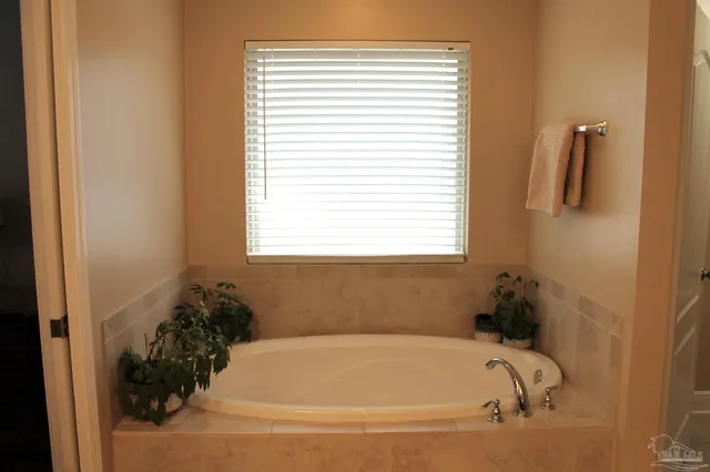 a white bath tub sitting in a bathroom next to a window
