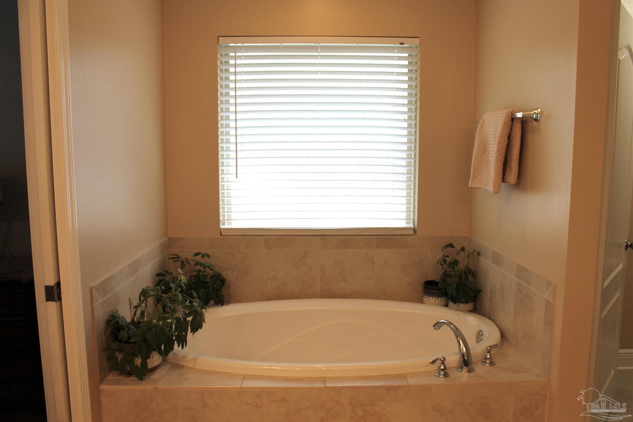 5468 Madelines Way Pace, FL 32571 - Photo 30 of 45 a white bath tub sitting in a bathroom next to a window