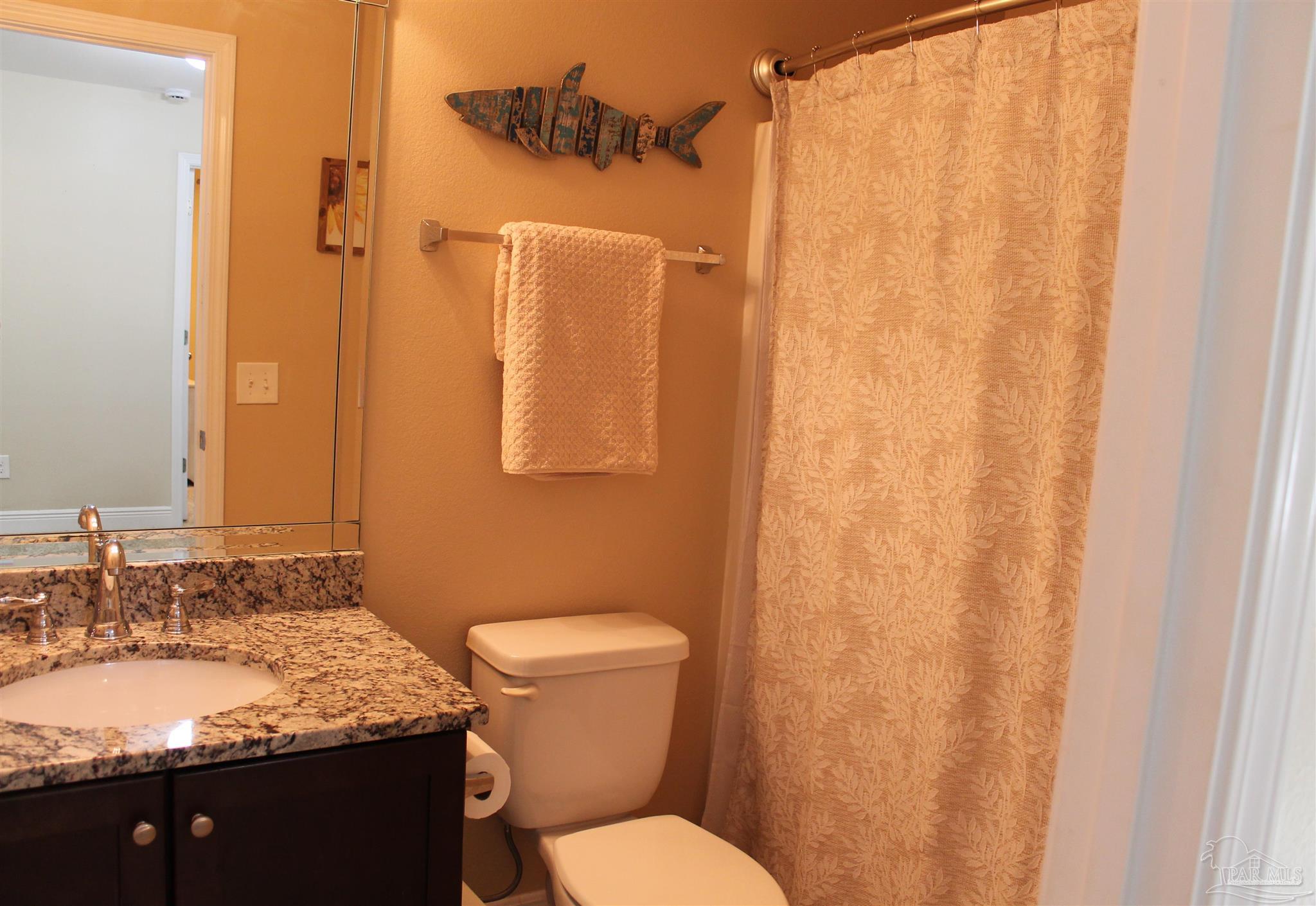 5468 Madelines Way Pace, FL 32571 - Photo 33 of 45 a bathroom with a granite countertop sink toilet and shower