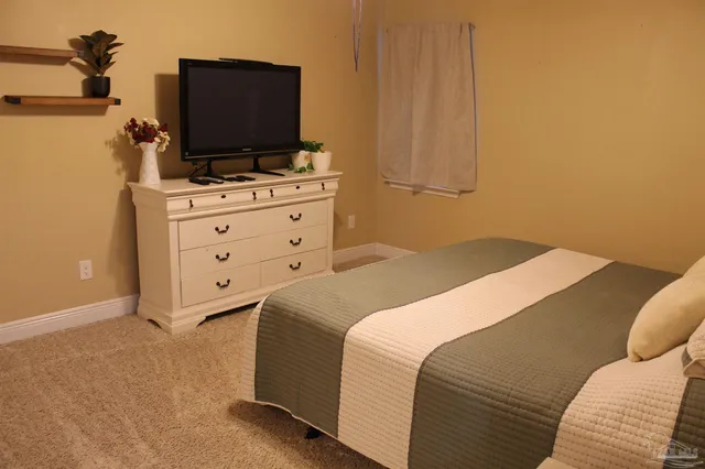 a bedroom with a bed and flat screen tv