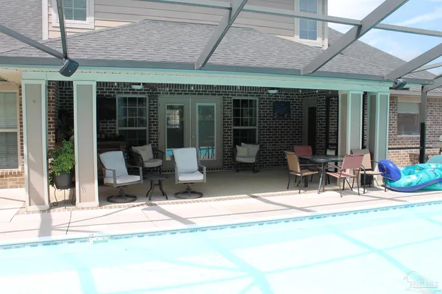 a view of a patio with table and chairs near a barbeque