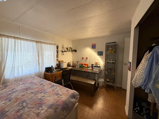 a bedroom with a bed and a flat tv screen on dresser