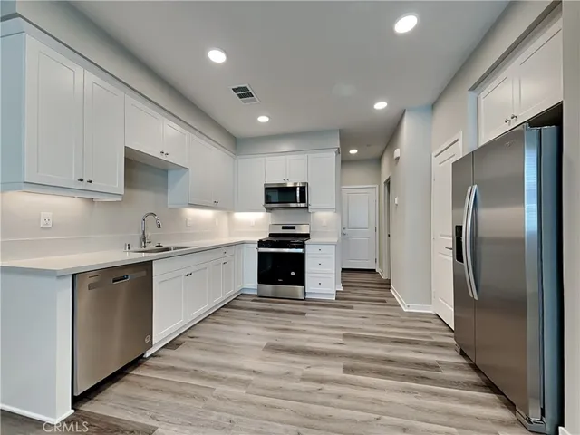 a kitchen with granite countertop a refrigerator and a stove top oven