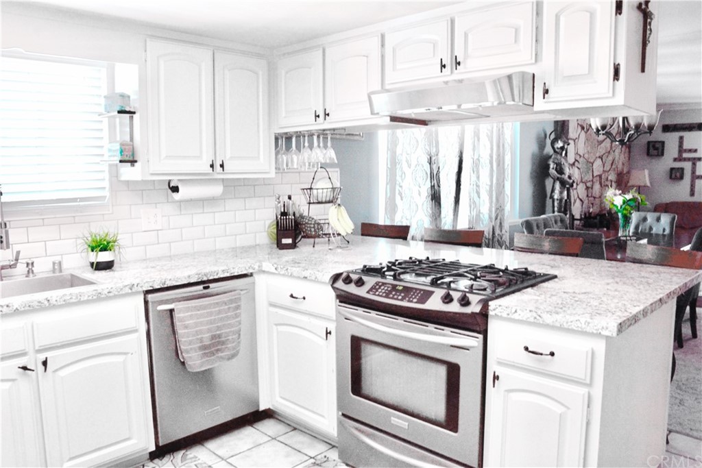 6038 KOA Drive Rialto, CA 92377 - Photo 3 of 18 a kitchen with white cabinets and appliances