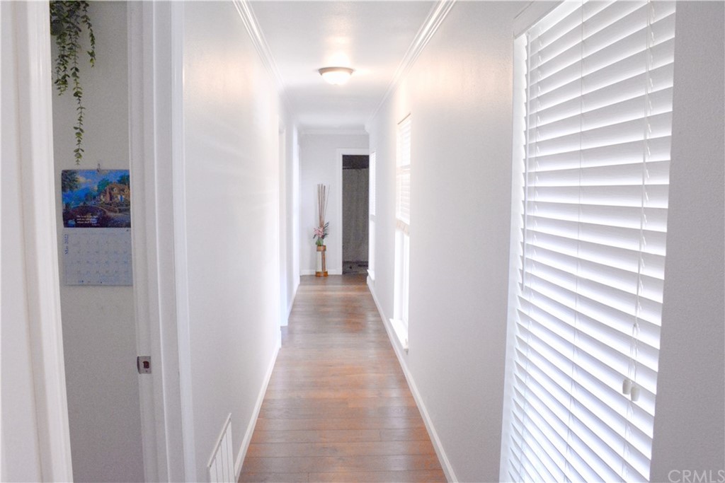 6038 KOA Drive Rialto, CA 92377 - Photo 7 of 18 a view of a hallway with wooden floor and a bathroom