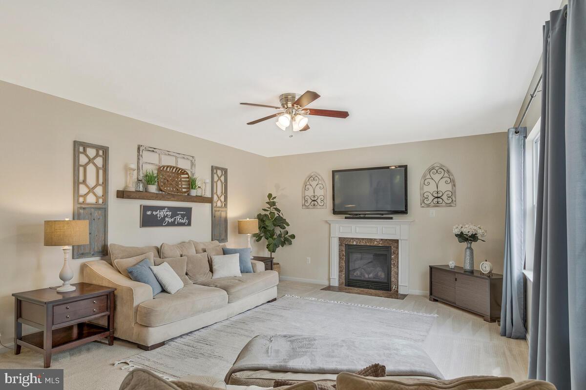 2066 Baythorne Road Prince Frederick, MD 20678 - Photo 18 of 54 a living room with furniture a flat screen tv and a fireplace