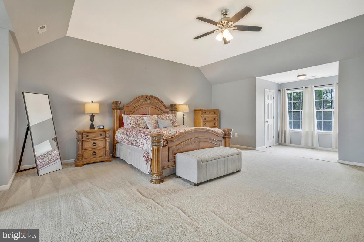 2066 Baythorne Road Prince Frederick, MD 20678 - Photo 26 of 54 a spacious bedroom with a bed a couch and a chandelier