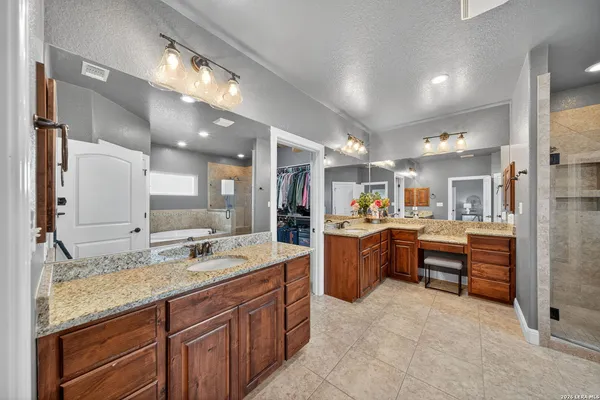 a spacious bathroom with a granite countertop double vanity sink and a mirror