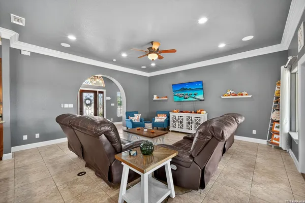 a living room with furniture kitchen view and a chandelier