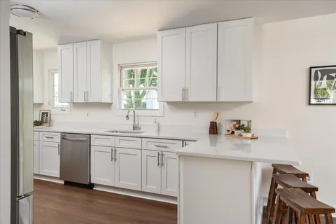 a kitchen with white cabinets and sink