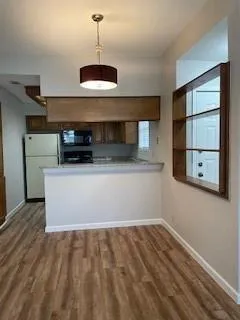 a kitchen with a stove and a wooden floor