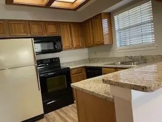 a kitchen with granite countertop a sink stove and microwave