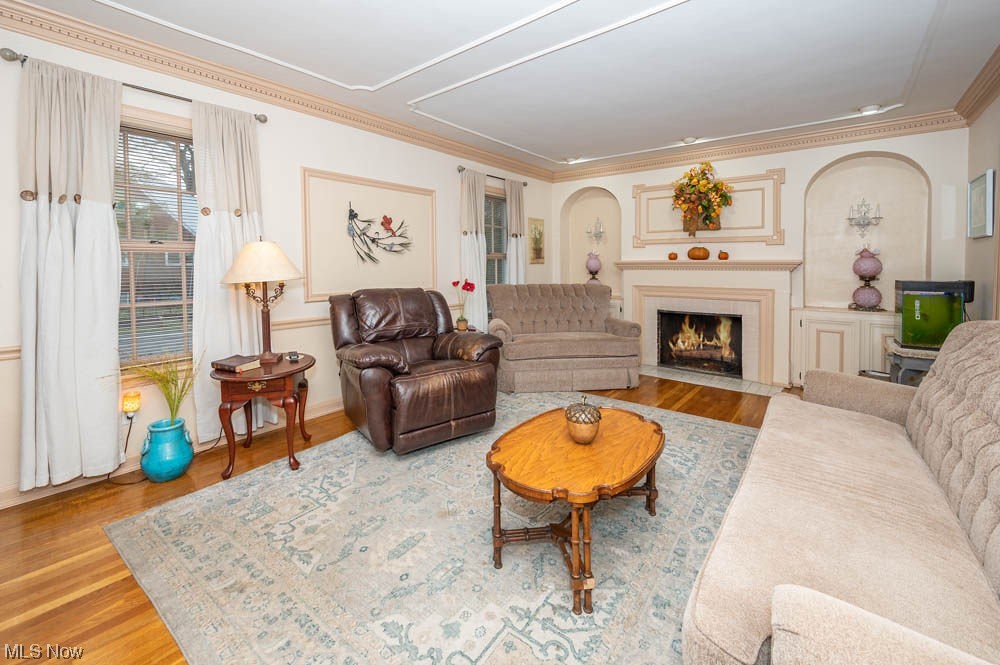 Living room with crown molding and light hardwood / wood-style floors