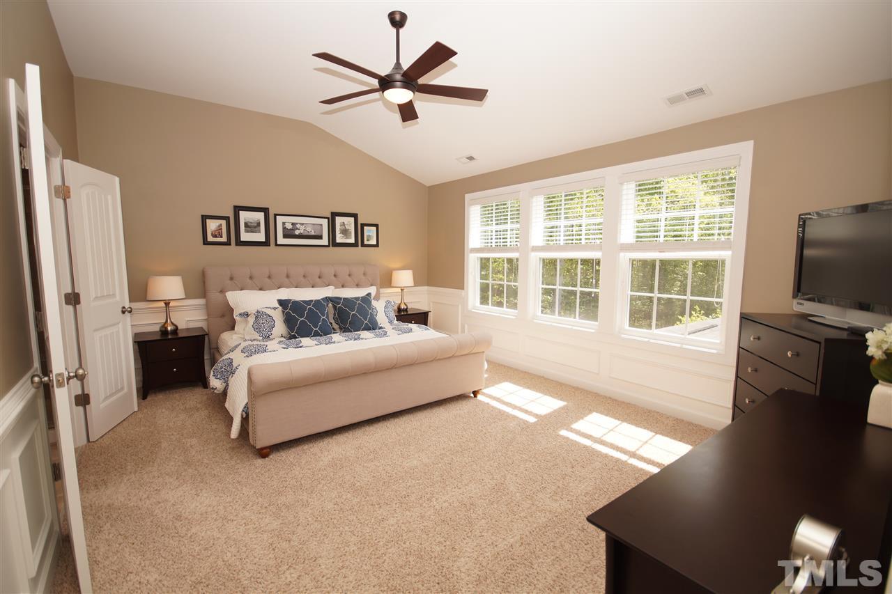 3015 Red Grape Drive Raleigh, NC 27607 - Photo 11 of 25 a spacious bedroom with a large bed a flat tv screen and a dresser