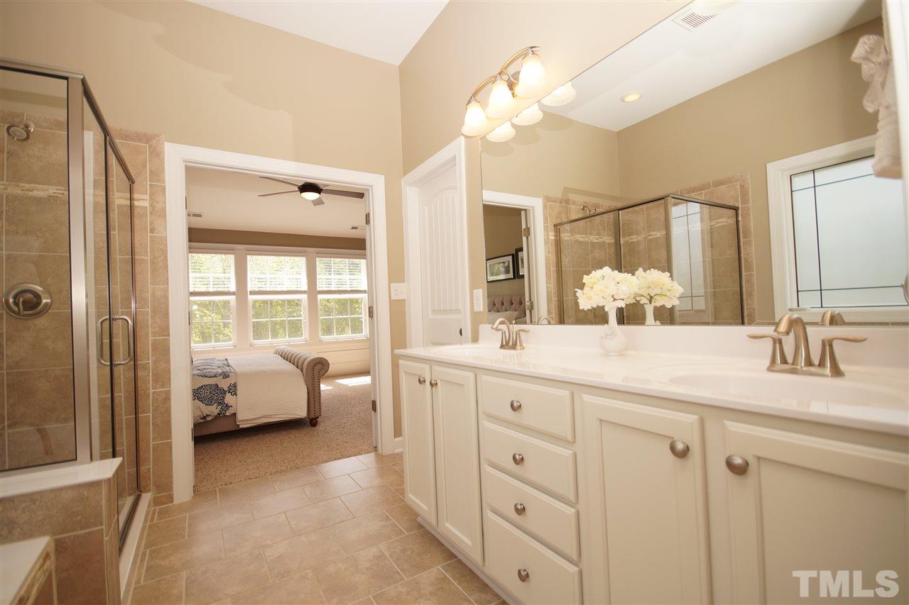 3015 Red Grape Drive Raleigh, NC 27607 - Photo 14 of 25 a en suite bathroom with a double vanity sink a large mirror and shower