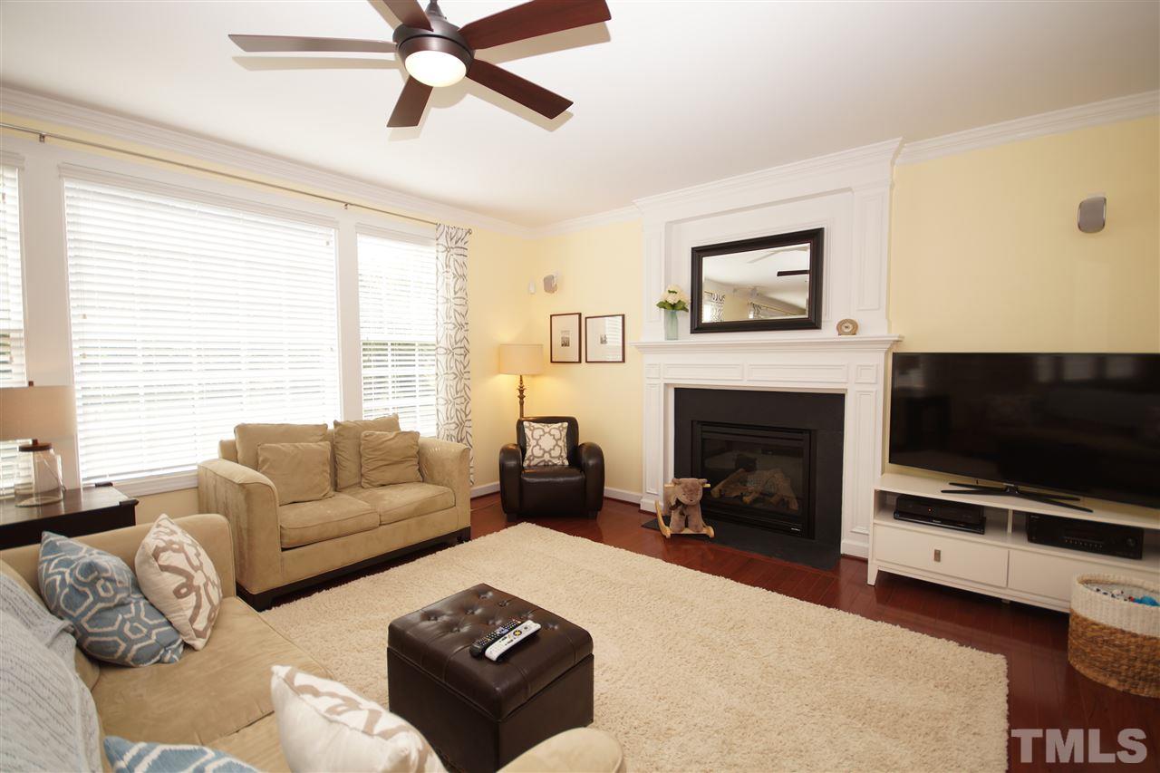 3015 Red Grape Drive Raleigh, NC 27607 - Photo 5 of 25 a living room with furniture a flat screen tv and a fireplace