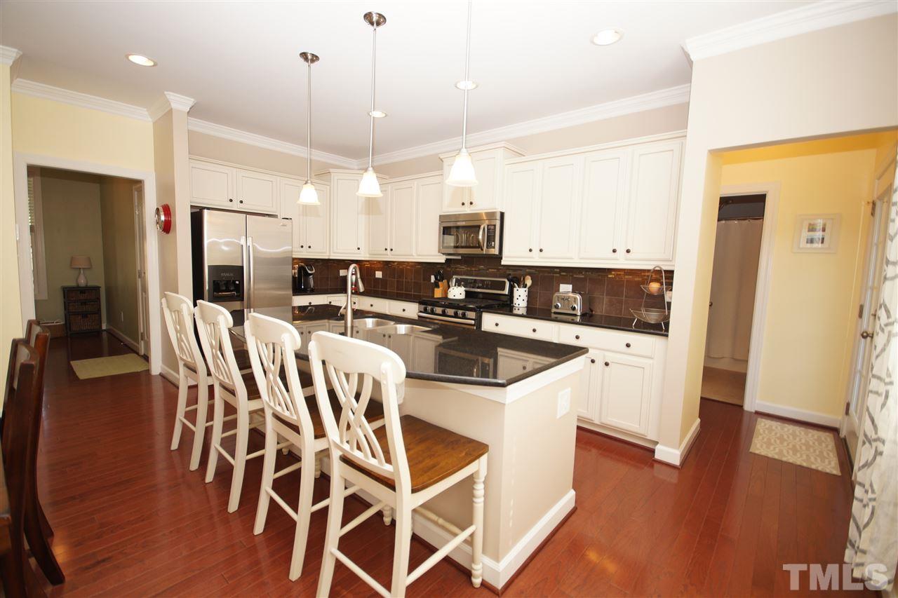 3015 Red Grape Drive Raleigh, NC 27607 - Photo 6 of 25 a kitchen with stainless steel appliances kitchen island granite countertop a refrigerator a stove a microwave oven a sink with island and chairs