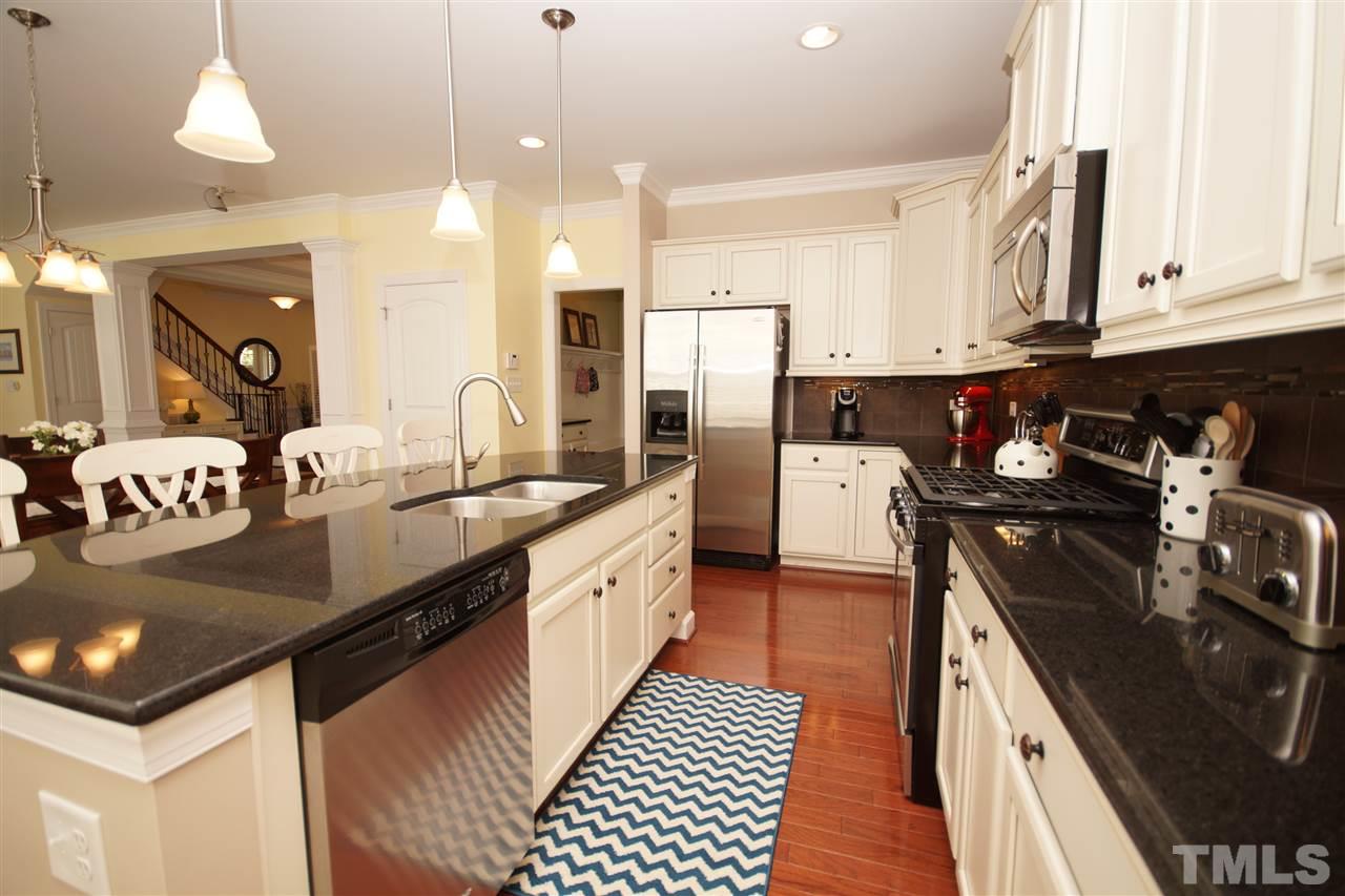 3015 Red Grape Drive Raleigh, NC 27607 - Photo 7 of 25 a kitchen with stainless steel appliances granite countertop a sink stove and refrigerator