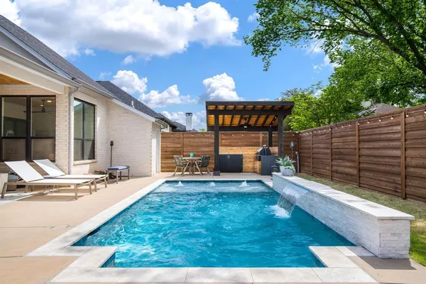 a view of a patio with table and chairs and wooden fence
