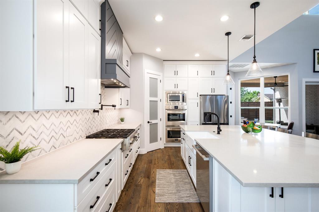 2093 Holt Way Grapevine, TX 76051 - Photo 8 of 40 a large kitchen with stainless steel appliances kitchen island a large counter top a stove a chimney a sink and a center island