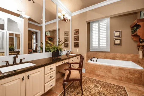 a bathroom with a granite countertop sink and a bathtub
