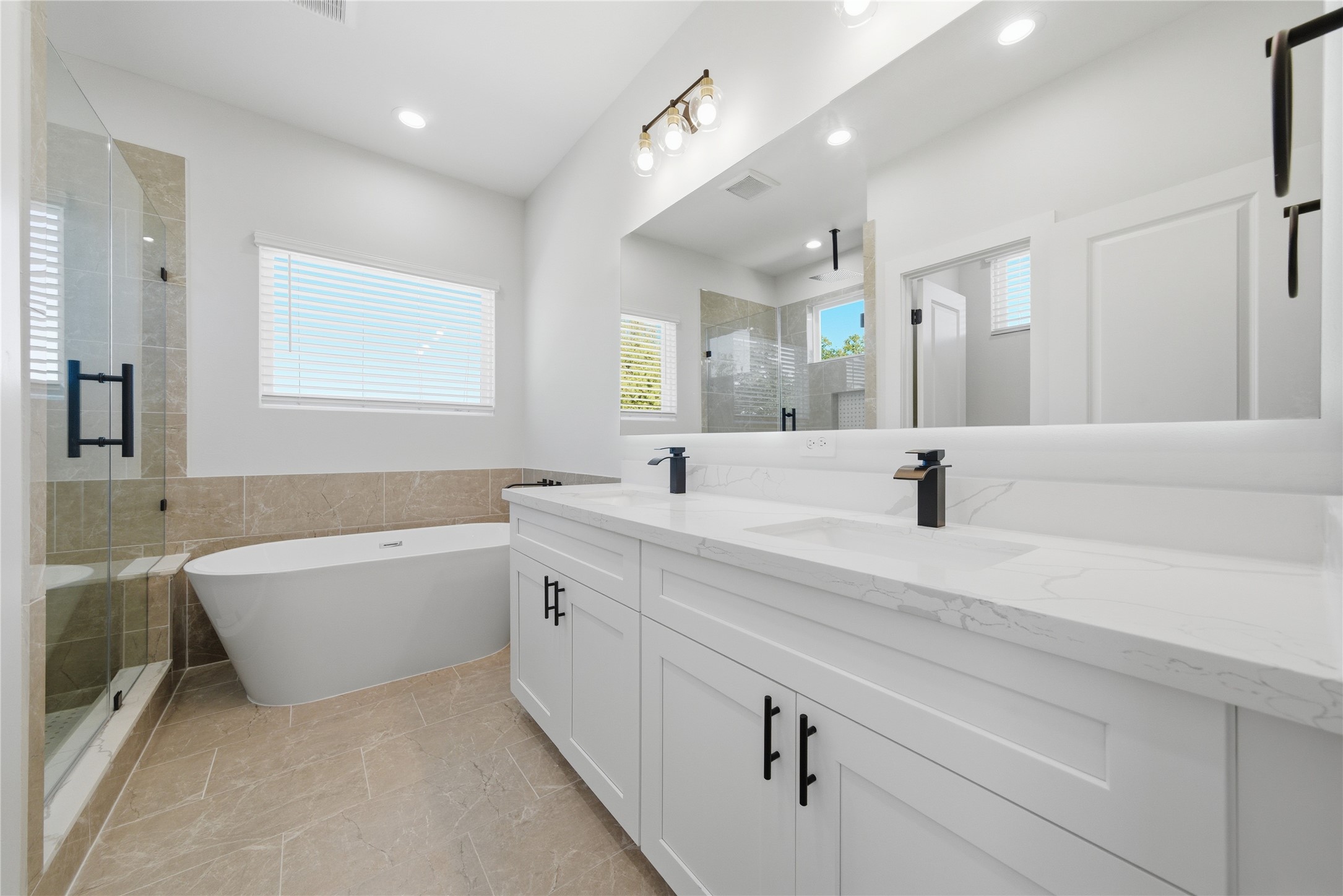 10929 Ivyridge Road, Unit B Houston, TX 77043 - Photo 12 of 37 a spacious bathroom with a bathtub a double vanity sink and mirror