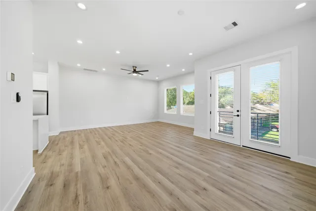 a large kitchen with a center island wooden floor and stainless steel appliances