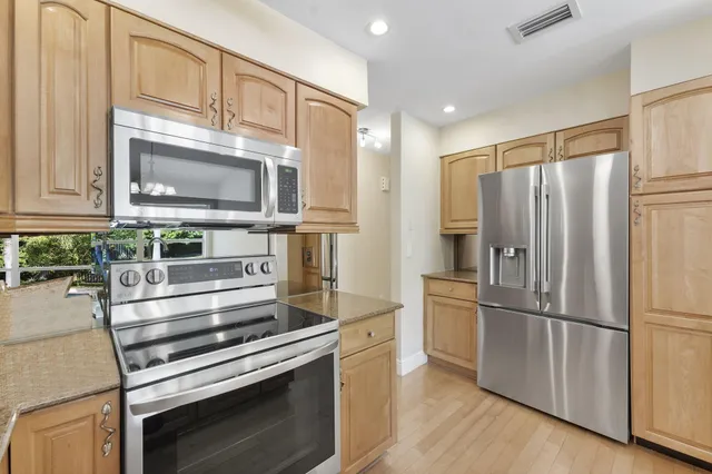 a kitchen with granite countertop stainless steel appliances and wooden cabinets