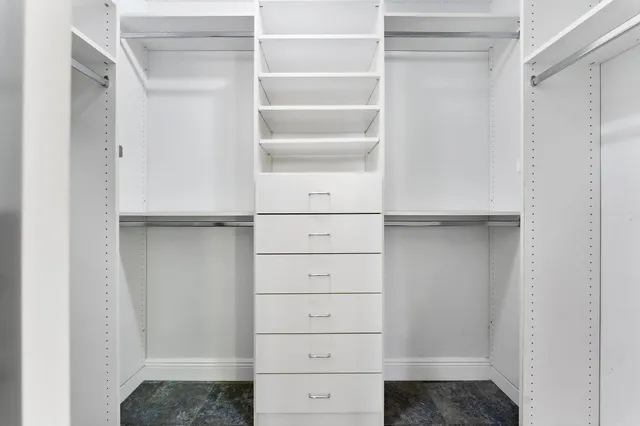 a view of walk in closet with empty racks