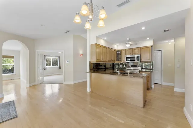 a view of kitchen with kitchen island refrigerator cabinets and living room view