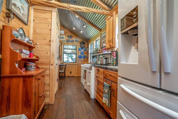a view of a kitchen with wooden floor and cabinets