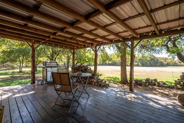 a patio with wooden floor a yard tables and chairs