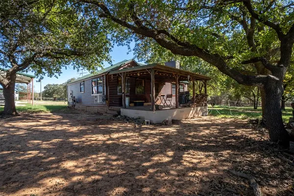 a view of a house with backyard and a tree