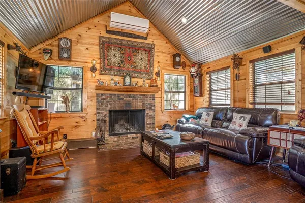 a living room with furniture a fireplace and wooden floor