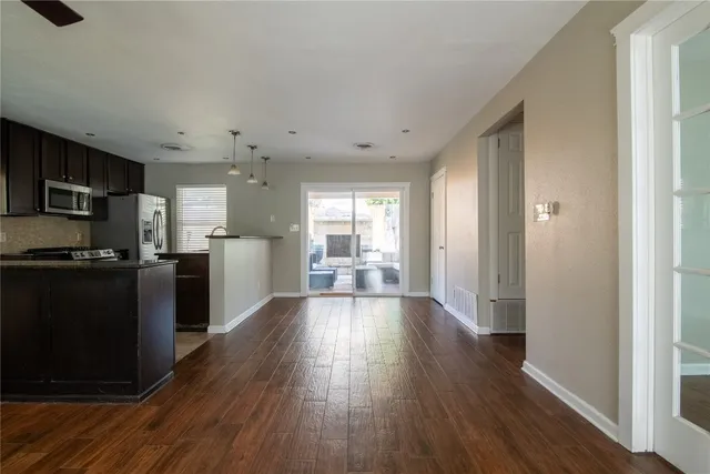 a view of a kitchen with wooden floor and electronic appliances