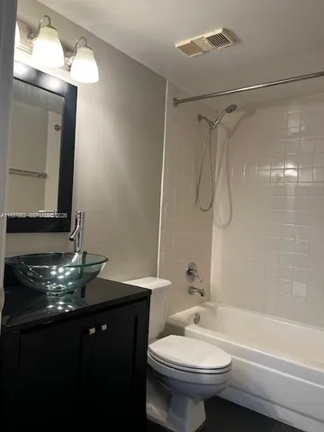 a bathroom with a bathtub sink vanity mirror and toilet