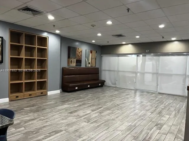 a view of an empty room with a cabinet and mirrors