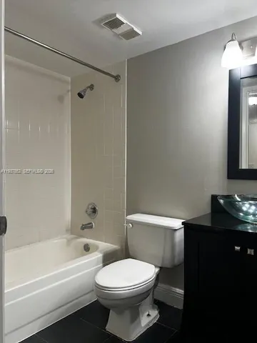 a white toilet sitting next to a bath tub