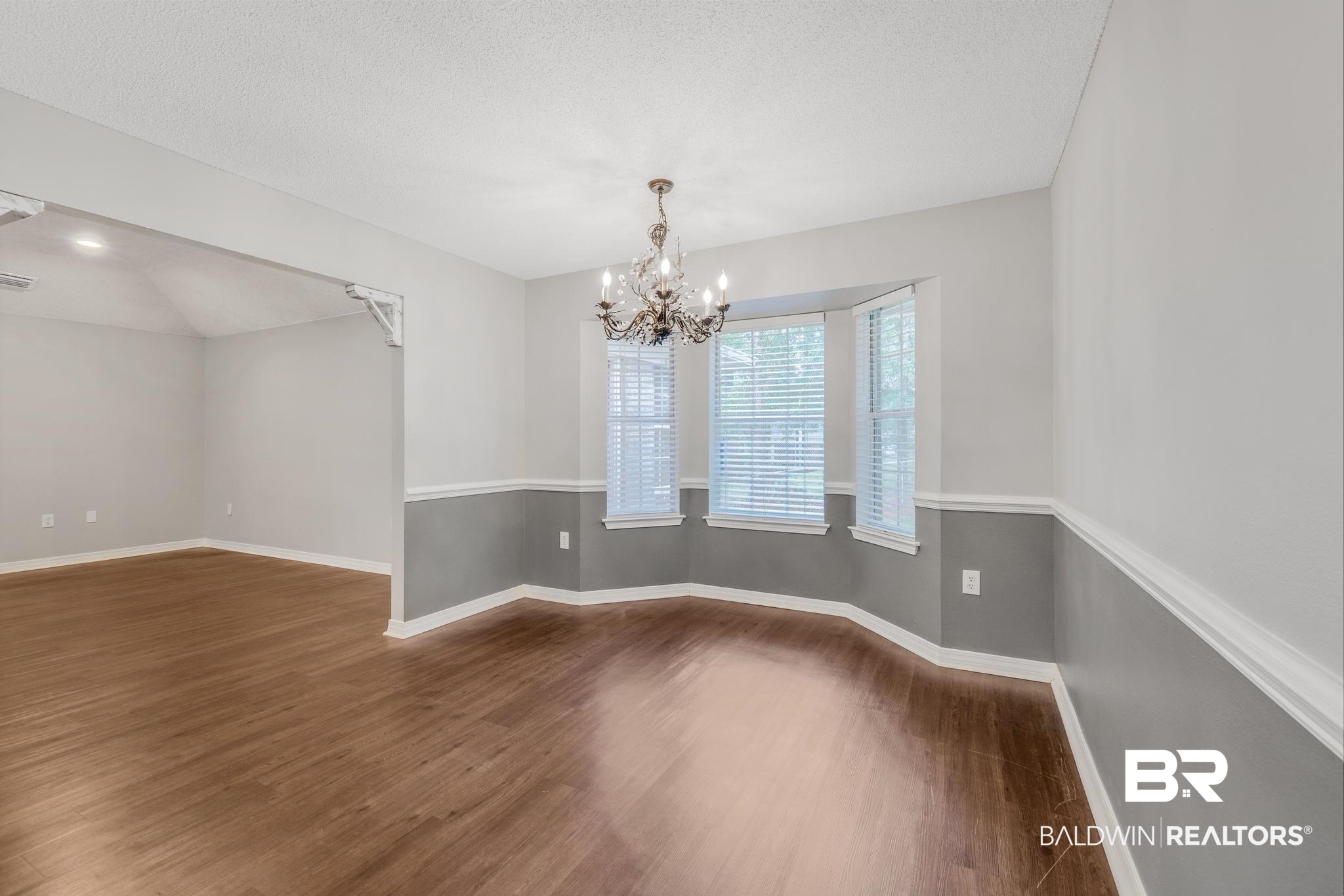 140 Hope Drive Daphne, AL 36526 - Photo 18 of 54 Spare room featuring dark wood-type flooring, a chandelier, and a textured ceiling