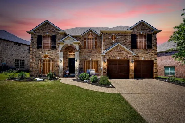 a front view of a house with a garden and yard