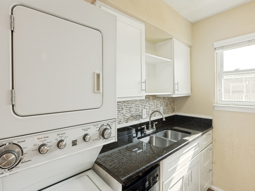 2401 Manor Road, Unit 218 Austin, TX 78722 - Photo 21 of 27 A well-appointed laundry area offers stacked units and ample counter space with a window for natural light.