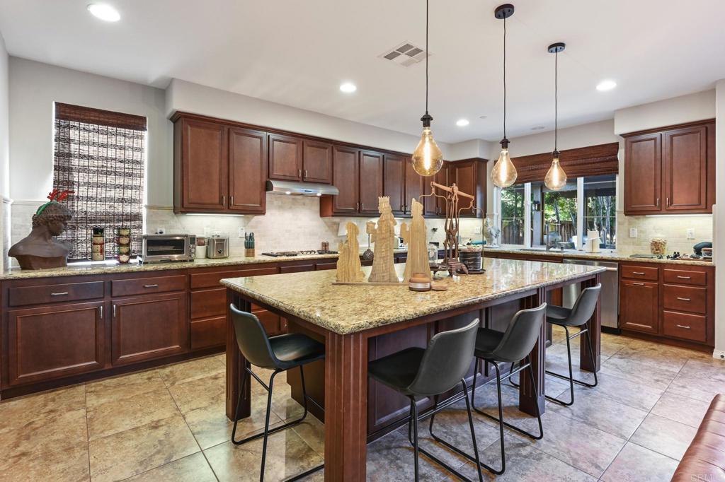 3524 North Fork Avenue Carlsbad, CA 92010 - Photo 7 of 37 a kitchen with stainless steel appliances granite countertop wooden cabinets a center island and a stove