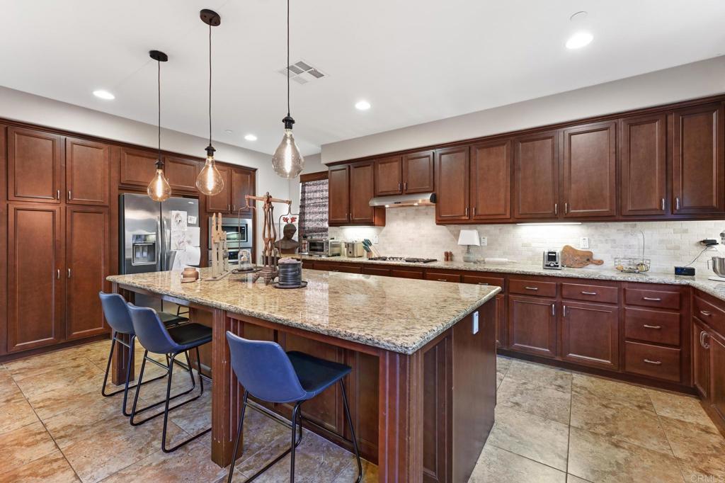 3524 North Fork Avenue Carlsbad, CA 92010 - Photo 8 of 37 a kitchen with stainless steel appliances granite countertop wooden cabinets a center island and a refrigerator