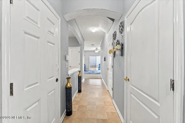 a view of a hallway with a livingroom and furniture